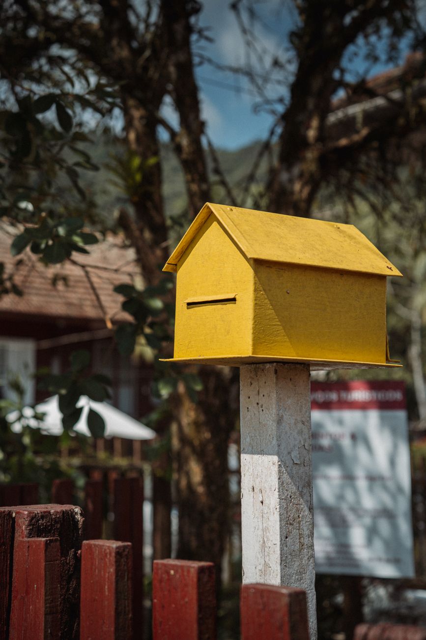 yellow mailbox in rustic backyard setting